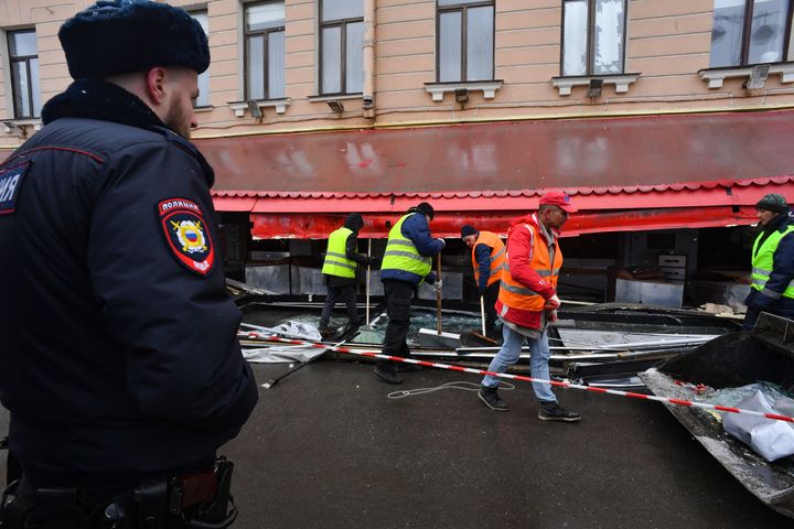 Municipal workers clean the debris in the aftermath of the April 2 bomb blast in a cafe in Saint Petersburg on April 3, 2023.