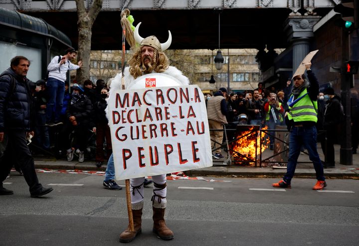 Ένας διαδηλωτής ντυμένος Γαλάτης κρατά ένα πλακάτ που γράφει «Ο Μακρόν κήρυξε τον πόλεμο στον λαό» κατά τη διάρκεια μιας διαδήλωσης ως μέρος της ενδέκατης ημέρας πανεθνικών απεργιών και διαμαρτυριών κατά της συνταξιοδοτικής μεταρρύθμισης της γαλλικής κυβέρνησης, στο Παρίσι, Γαλλία, 6 Απριλίου 2023.
