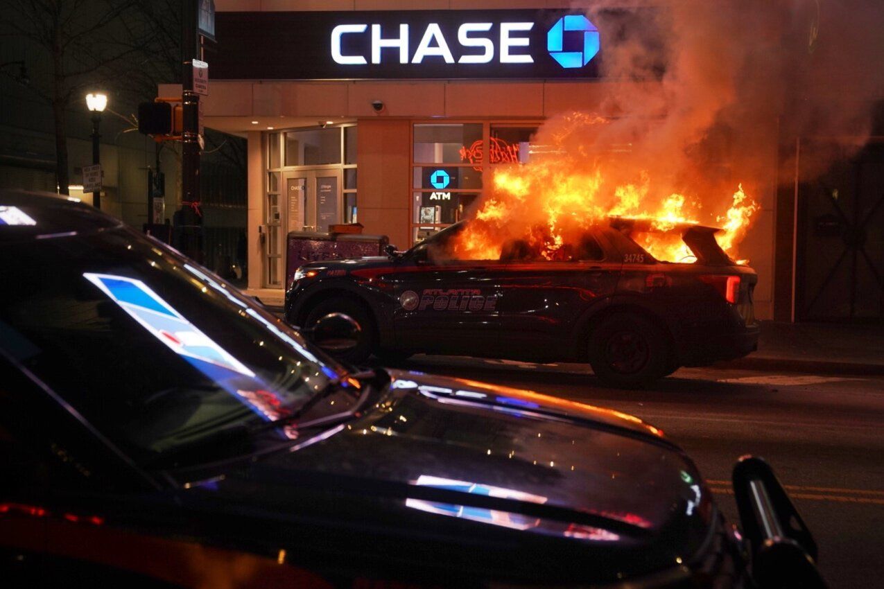 A burning police cruiser is seen as demonstrators protest Terán's death, Jan. 21, in Atlanta.