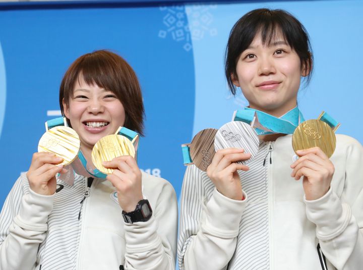 記者会見で、獲得したメダルを手に笑顔を見せるスピードスケートの高木菜那さん（左）と高木美帆さん＝2018年2月25日、韓国・平昌