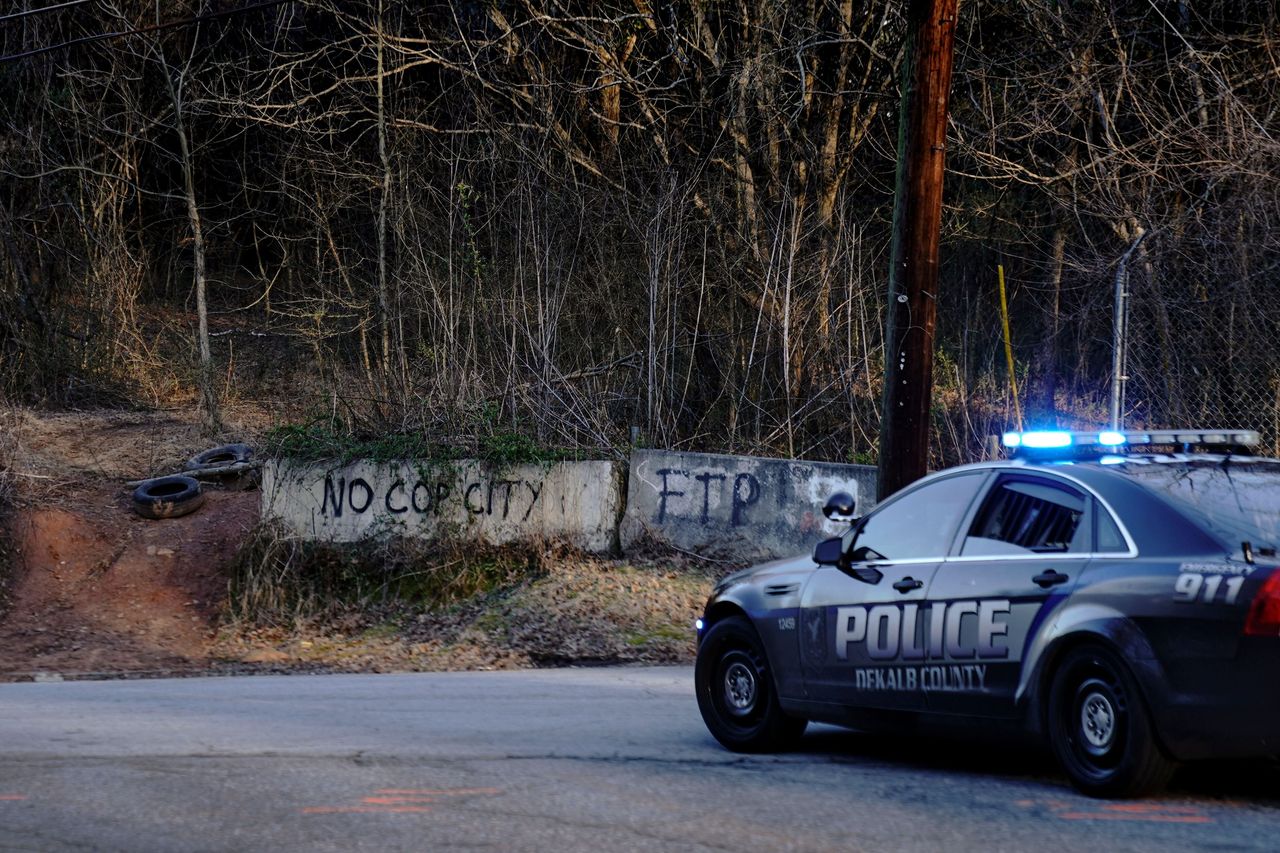 A police car drives past the planned site of a law enforcement training facility, which activists have nicknamed "Cop City," following the first raid since the death of environmental activist Manuel Terán, near Atlanta, Feb. 6.