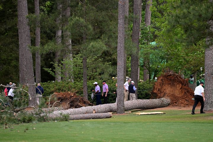 Course officials look over fallen trees Friday on the 17th hole during the second round of the Masters Tournament at Augusta National Golf Club in Georgia.