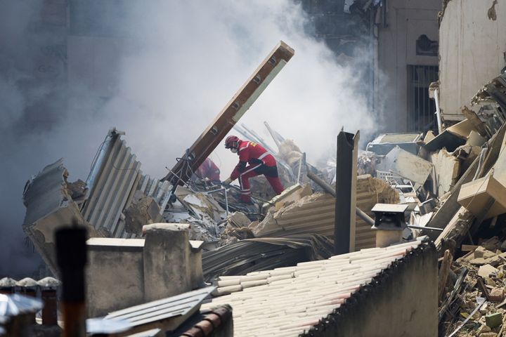 A firefighter works on rubble at the "rue Tivoli" after a building collapsed in the same street, in Marseille, France, on April 9, 2023.