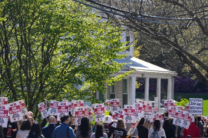 Strikers march in front of Rutgers' buildings in New Brunswick, N.J., Monday, April 10, 2023. Thousands of professors, part-time lecturers and graduate student workers at New Jersey's flagship university have gone on strike — the first such job action in the school's 257-year history. (AP Photo/Seth Wenig)