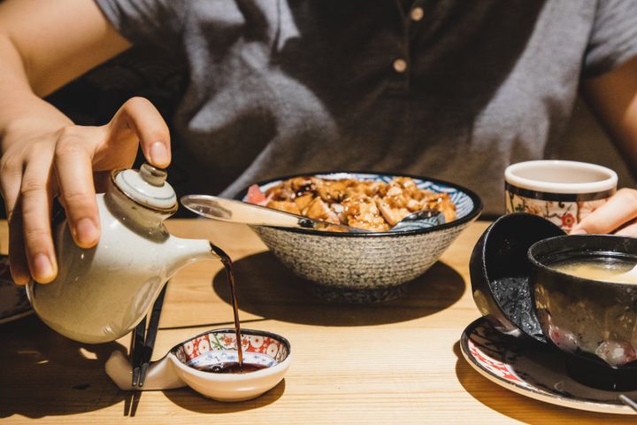 Soy sauce is poured into a saucer served alongside Japanese cuisine.