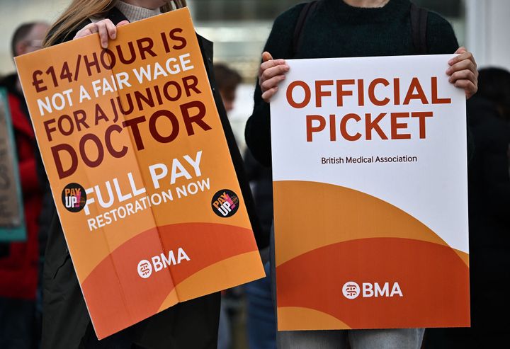 People hold British Medical Association (BMA) branded placards calling for better pay, as they stand on a picket line outside University College Hospital (UCH) 