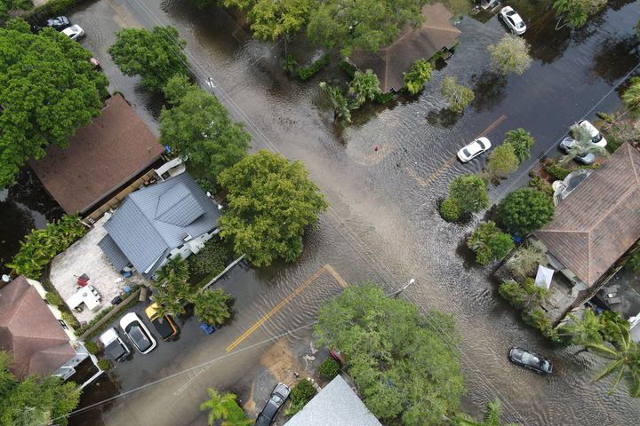 A pair of waterlogged cars sit abandoned in the road as floodwaters recede in the Sailboat Bend neighborhood of Fort Lauderdale, Fla., on April 13, 2023. Over 25 inches of rain fell in South Florida since Monday, causing widespread flooding.