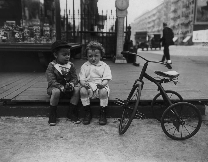 Two boys ― dressed in what we traditionally think of as "boys' clothes" ― share candy on a New York street, circa 1925.