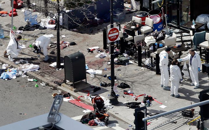 Investigators examine the scene of the second bombing near the finish line of the 2013 Boston Marathon the day after two blasts killed three and injured more than 260 people. 