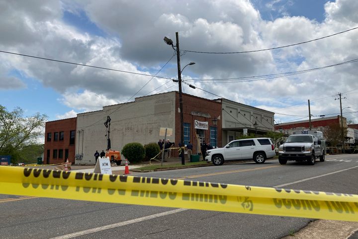 Investigators work at the site of Saturday night's fatal shooting in downtown Dadeville, Alabama.
