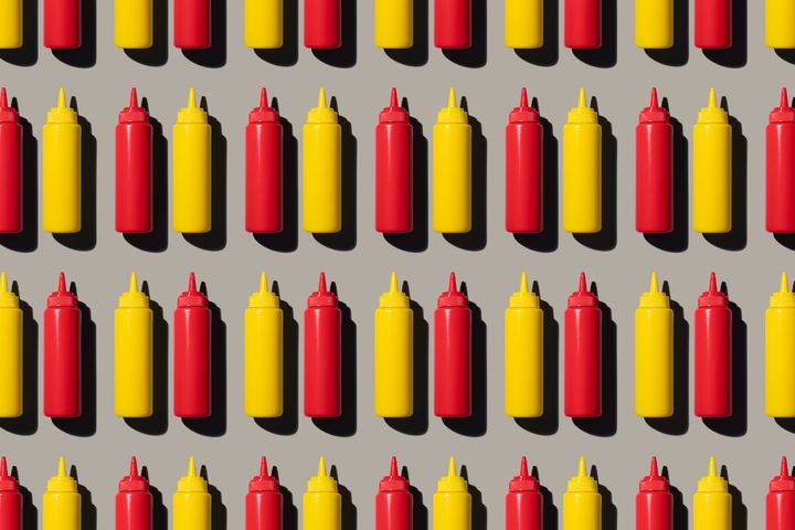 Rows of ketchup and mustard bottles.