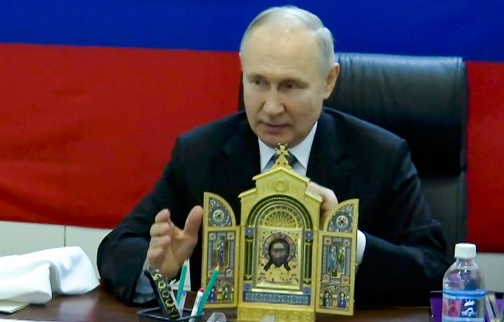 In this photo taken from video released by Russian TV Pool on April 18, 2023, Russian President Vladimir Putin shows an icon prior to present at one of headquarters of the Russian troops at an undisclosed location. 