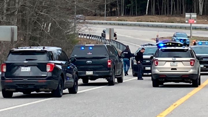 Members of law enforcement approach vehicles at a scene where people were injured in a shooting on Interstate 295 in Yarmouth, Maine, Tuesday, April 18, 2023. Gunfire that erupted on the busy highway in Maine is linked to a second crime scene where people have been found dead in a home about 25 miles away in the town of Bowdoin, Maine, state police said Tuesday. (AP Photo/Patrick Whittle)