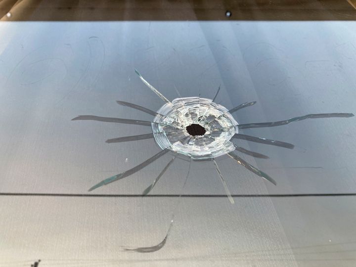 A bullet hole is visible in the glass transom over the door at the Mahogany Masterpiece dance studio in Dadeville, Ala., on April 16, 2023. 
