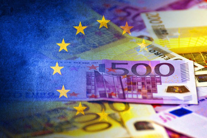 European Union flag and euro cash bills (money, economy, business, finance, inflation, crisis)