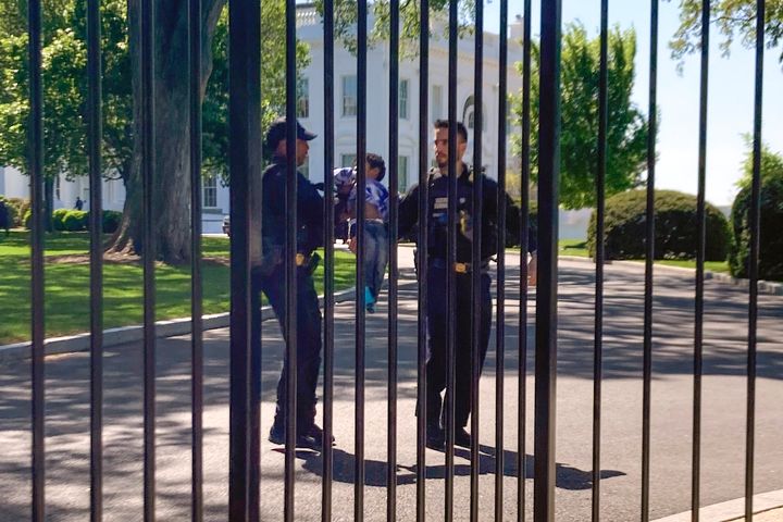 US Secret Service uniformed division police officers carry a young child who crawled through the White House fence on Pennsylvania Avenue in Washington. 