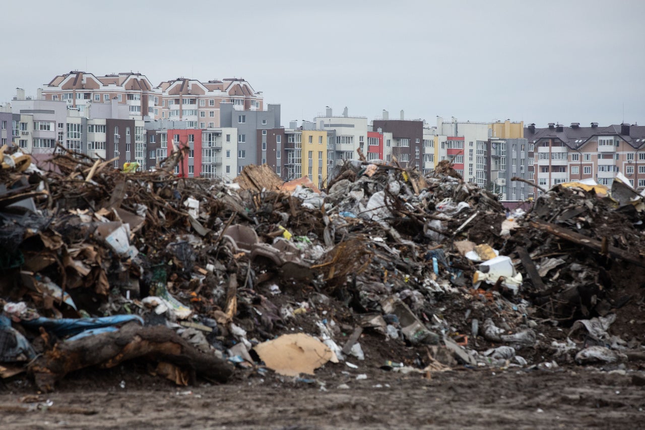 A municipal dump in Bucha is seen in front of residential buildings at cemetery of civilian vehicles which were destroyed by Russian troops.