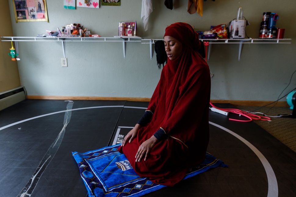 Ibrahim prays in her dorm room before wrestling practice, April 16. "I want other Muslim women who want to compete in wrestling, or anything else, to know they're able to do it without compromising their religion," she said.