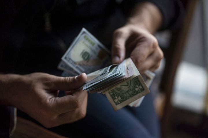 A person counts U.S. dollar banknotes. Photographer: Moe Zoyari/Bloomberg