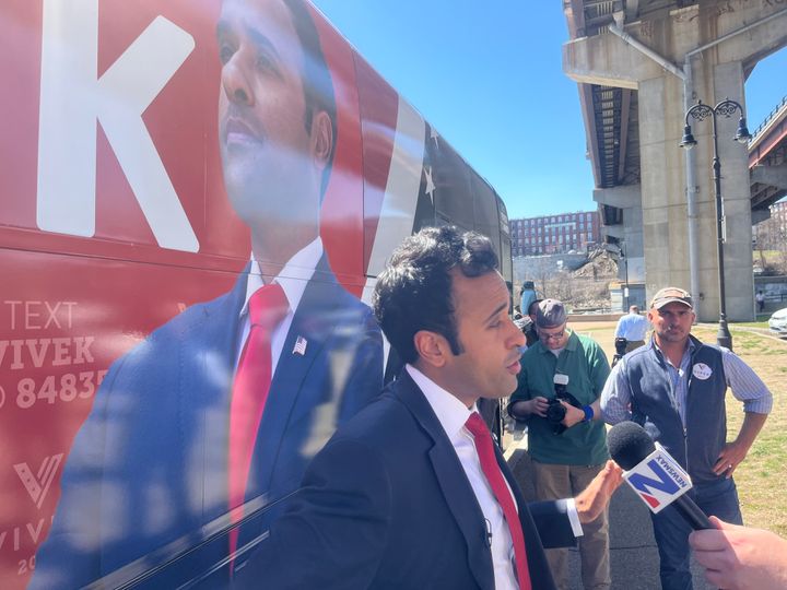 Republican candidate for president Vivek Ramaswamy takes questions from reporters beside his campaign bus following a lunch campaign stop at a local restaurant in Manchester, New Hampshire.