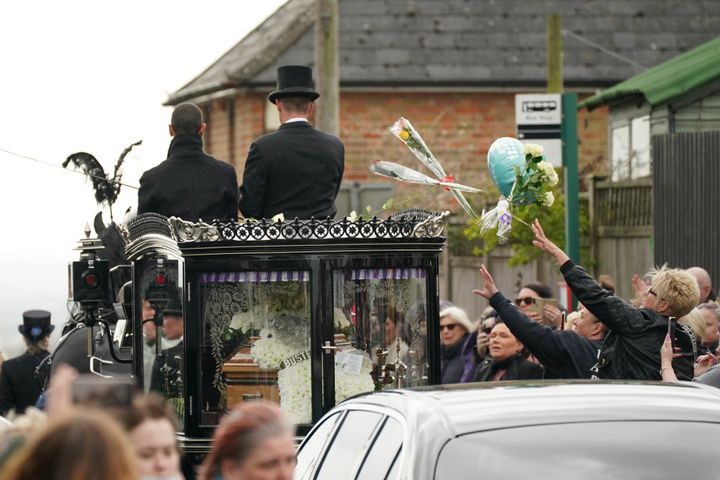Some mourners threw flowers as Paul's coffin passed them