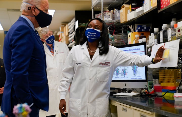 President Joe Biden listens to Kizzmekia Corbett, an immunologist with the National Institutes of Health, during a visit to the Viral Pathogenesis Laboratory in 2021. Critics of GOP-proposed spending caps say they would wind up cutting domestic programs like the NIH.