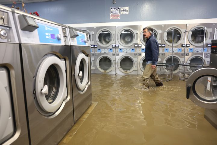 PAJARO, CALIFORNIA - MARCH 14: Patrick Cerruti walks through the flooded Pajaro Coin Laundry on March 14, 2023 in Pajaro, California. Northern California has been hit by another atmospheric river that has brought heavy rains and flooding throughout the region. The town has been inundated with floodwaters since Saturday after a levee was breached along the Pajaro River. (Photo by Justin Sullivan/Getty Images)