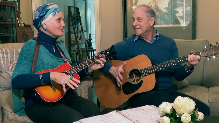 Lynda Shannon Bluestein, left, jams with her husband, Paul, in the living room of their home, Feb. 28, 2023, in Bridgeport, Conn. In March, Bluestein, who has terminal fallopian tube cancer, reached a settlement with the state of Vermont that will allow her to be the first non-resident to use its medically assisted suicide law.