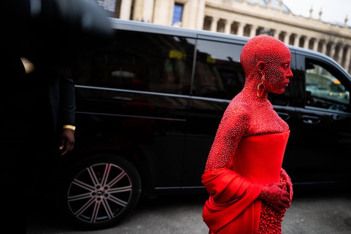 Doja Cat wearing a red Schiaparelli total look and red makeup all over the body, outside Schiaparelli, during Paris Fashion Week.