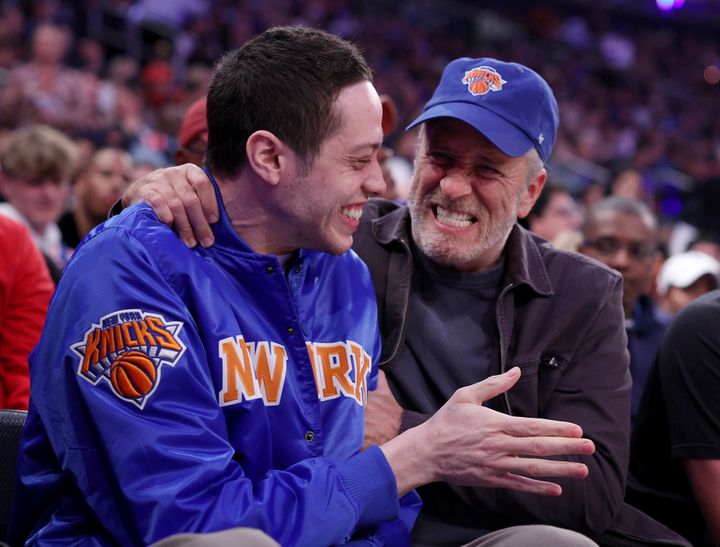 Pete Davidson and fellow comedian Jon Stewart at the Knicks playoff game on April 23, 2023. An overzealous fan knocked the smile off Davidson's face later.