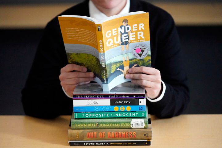 FILE - Amanda Darrow of the Utah Pride Center poses with books that have been the subject of complaints from parents. With legislators in Florida barring even the mention of being gay in classrooms and similar restrictions being considered in other states, books with LGBTQ+ themes remain the most likely targets of bans or attempted bans at public schools and libraries around the country, according to a new report on Monday. Maia Kobabe’s graphic memoir “Gender Queer,” was the most “challenged” book of 2022, the second consecutive year it has topped the list.