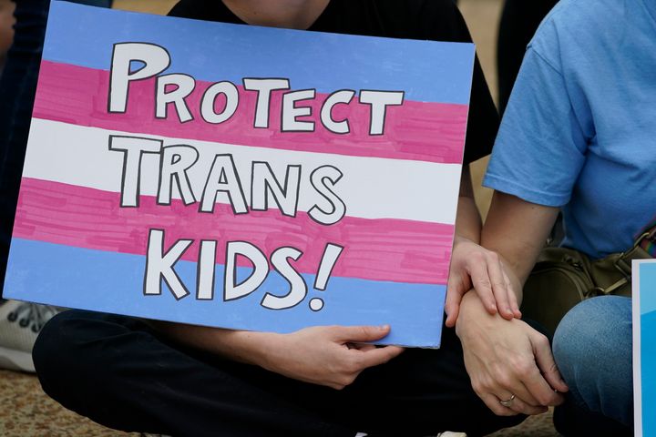 A protester holds a poster calling for lawmakers to protect trans children by voting against House Bill 1125, which would ban gender-affirming care for trans children at the Mississippi Capitol in Jackson, Wednesday, Feb. 15, 2023. (AP Photo/Rogelio V. Solis)