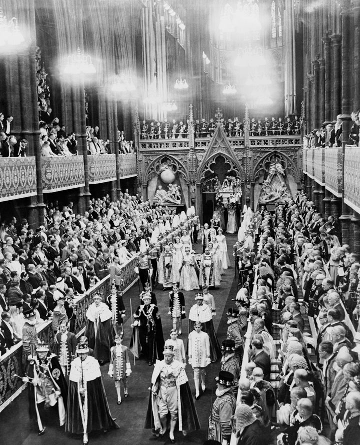 Queen Elizabeth II wearing the Imperial Crown and carrying the Orb and Scepter leaving Westminster Abbey at the end of her coronation ceremony. Throughout 20th century coronations, it was customary for chairs and stools to be specially designed for those attending and to include the royal cypher.