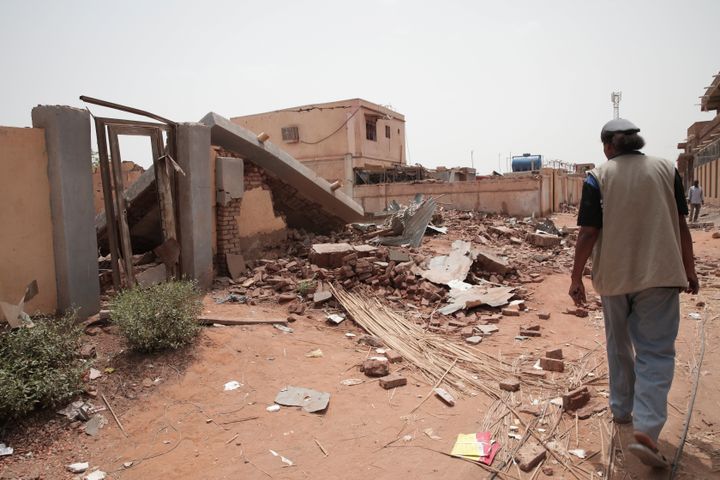 A man walks by a house hit in recent fighting in Khartoum, Sudan, Tuesday, April 25, 2023. 