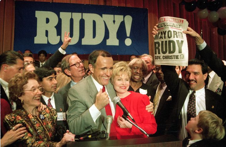 Giuliani celebrates as a supporter holds a newspaper with a headline declaring him the city's new mayor on Nov. 3, 1993. 