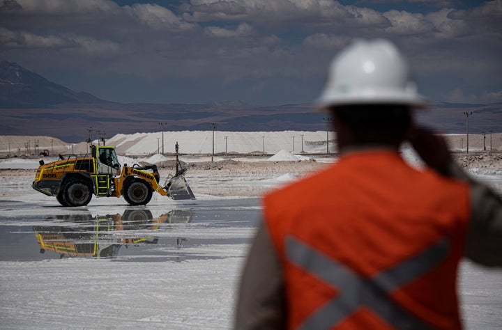 A worker observes machinery in a brine pool at the Chilean company SQM's lithium mine in the Atacama Desert on Sept.12, 2022.