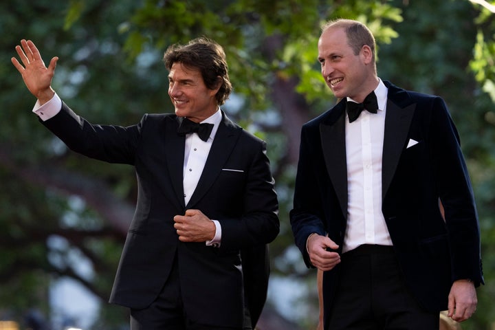 Prince William and actor Tom Cruise acknowledge the crowd as they attend the Top Gun: Maverick royal film Performance on May 19, 2022, in London.