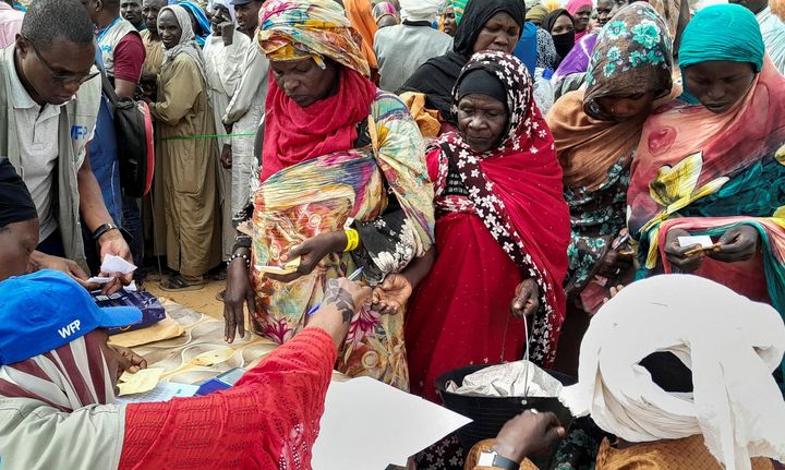 Απλωμένα χέρια για ένα κουπόνι που εξασφαλίζει λίγη τροφή. Σύνορα Σουδάν Τσαντ
