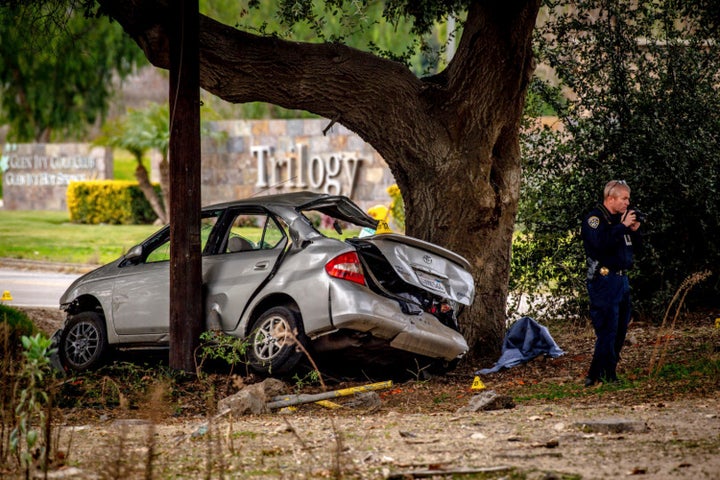 An officer with the California Highway Patrol's (CHP) Multidisciplinary Accident Investigation Team (MAIT) investigates the scene of a deadly crash in the Temescal Valley, south of Corona, California., Monday, Jan. 20, 2020. 