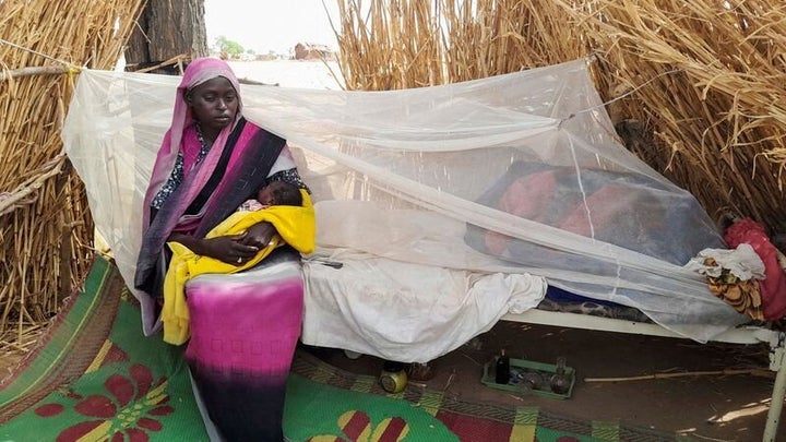  country, sits holding her baby among her belongings near the border between Sudan and Chad in Koufroun, Chad April 27, 2023. REUTERS/Mahamat Ramadane/File Photo