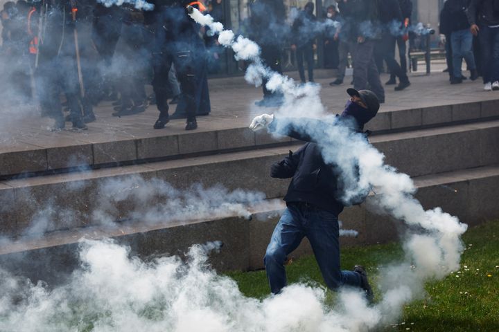Ένας διαδηλωτής ρίχνει δακρυγόνα κατά τη διάρκεια της παραδοσιακής εργατικής πορείας της Πρωτομαγιάς, ημέρα κινητοποίησης κατά του γαλλικού νόμου για τη μεταρρύθμιση του συνταξιοδοτικού συστήματος και για κοινωνική δικαιοσύνη, στη Νάντη της Γαλλίας την 1η Μαΐου 2023. REUTERS/Stephane Mahe