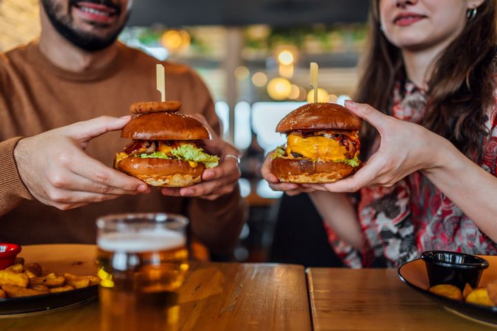Young hungry couple ready to eat tasty burgers in the pub