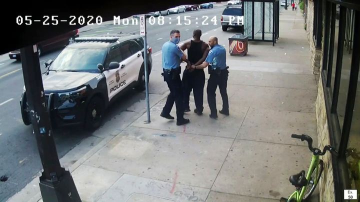 FILE - This image from video shows Minneapolis Police Officers Thomas Lane, left and J. Alexander Kueng, right, escorting George Floyd, center, to a police vehicle outside Cup Foods in Minneapolis, on May 25, 2020. 