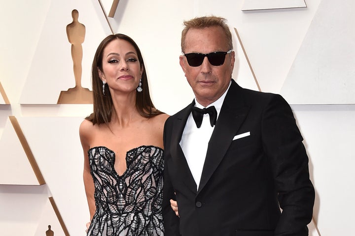 Christine Baumgartner, left, and Kevin Costner, right, are divorcing, a representative for the actor said.