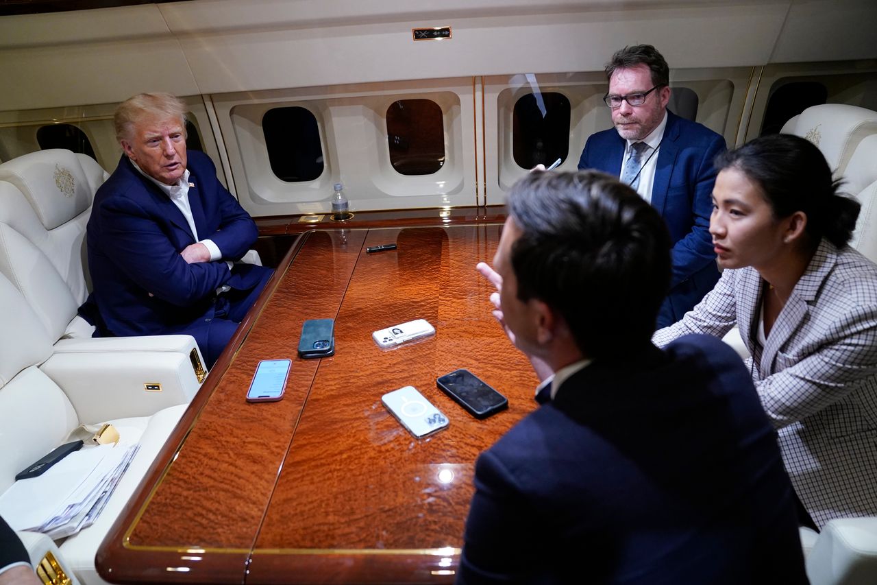 Trump speaks with reporters aboard his plane after a campaign rally in Waco, Texas, on March 25, 2023, while en route to his resort in Palm Beach, Florida.