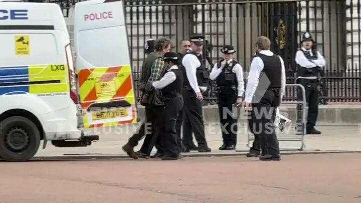 This image from a video shows police leading a man inside a police van outside Buckingham Palace on May 2. London police said a controlled explosion was carried out as a precaution outside Buckingham Palace late Tuesday after a man was arrested there on suspicion of possessing an offensive weapon.