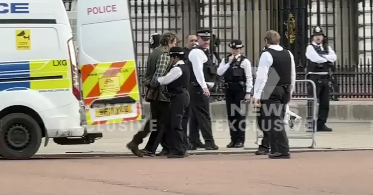Un homme arrêté devant le palais de Buckingham avant le couronnement du roi Charles