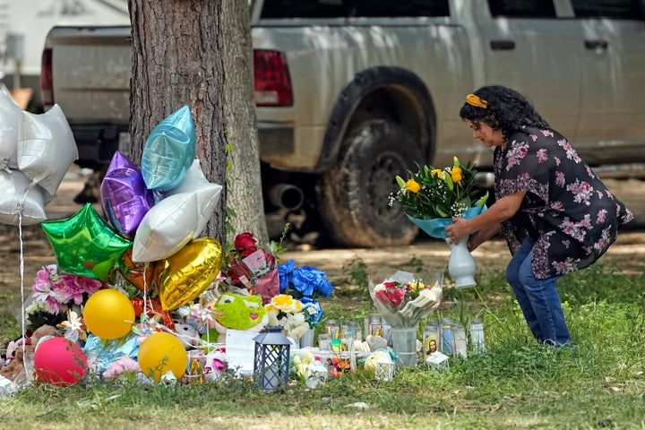 Maria Rodriguez places flowers Tuesday, May 2, 2023, outside the home where a mass shooting occurred Friday, in Cleveland, Texas.