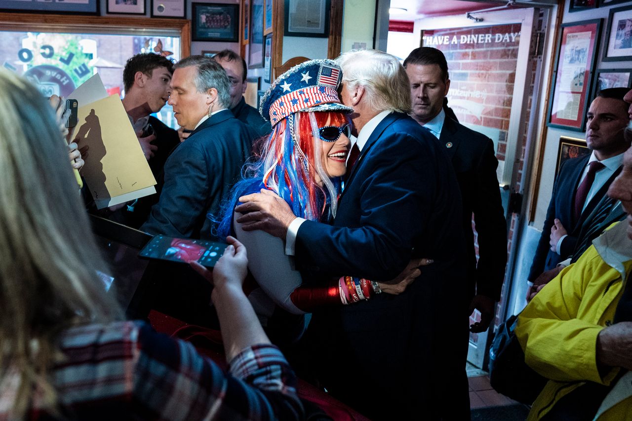 Trump greets convicted rioter Micki Larson-Olson while visiting the Red Arrow Diner after a campaign rally on Thursday, April 27, 2023, in Manchester, New Hampshire. 
