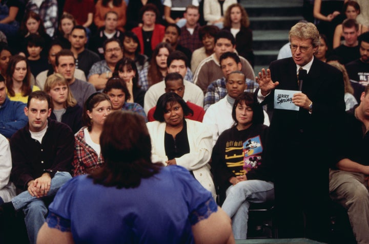 Springer engages with a guest on an episode of his show titled "I Am a Slave to My 600 Lb. Wife."